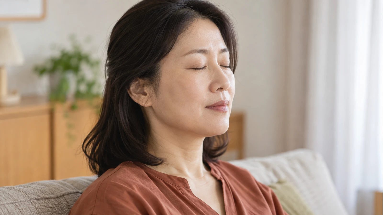 소파에서 양 눈을 편안하게 감고 있는 갈색 상의 성인